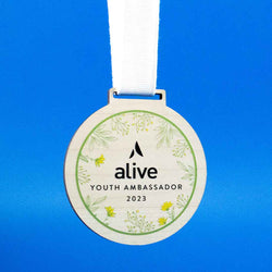 A collection of sustainable wood accessories, including eco-friendly medallions, personalized nameplates, and custom wood lapel pins.